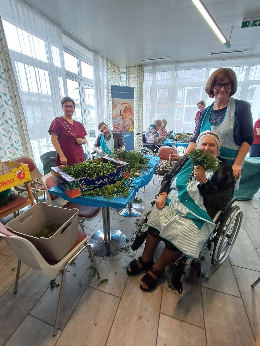 Bewohner und Ehrenamtliche beim Palmbuschen binden.