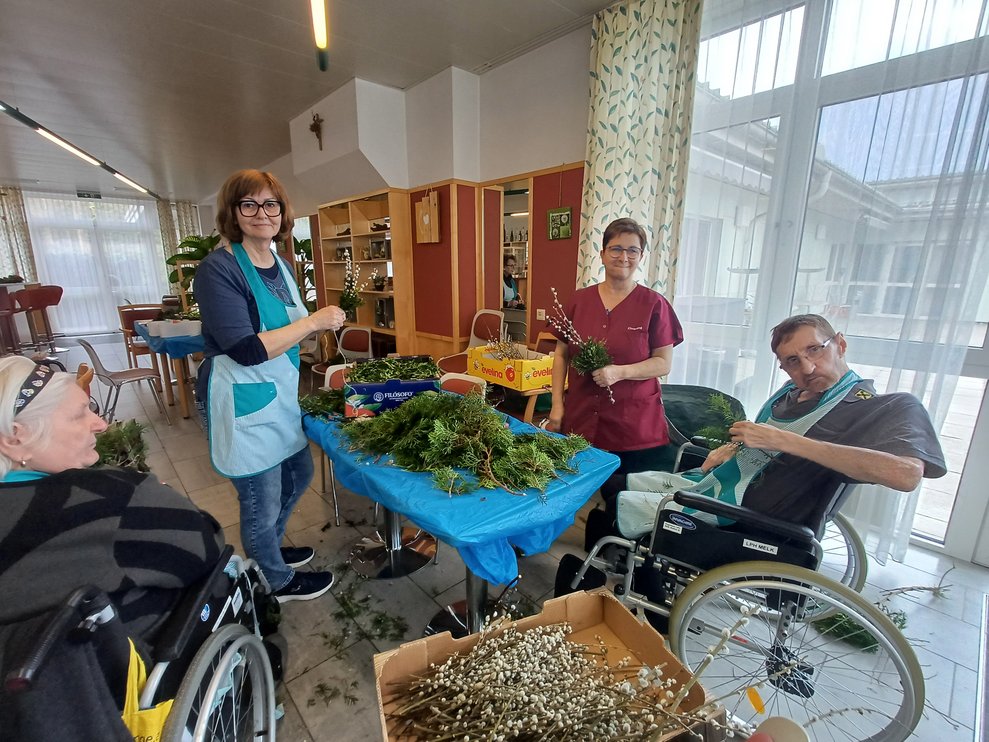 Bewohner und Ehrenamtliche beim Palmbuschen binden.