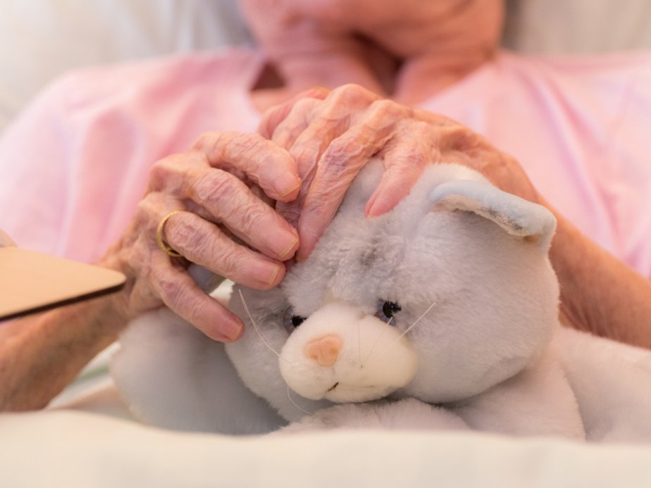 Eine Bewohnerin hält ein Kuscheltier in der Hand.