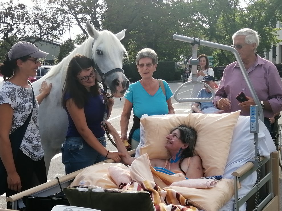 Eine Bewohnerin, ihre Familie und ein Pferd.