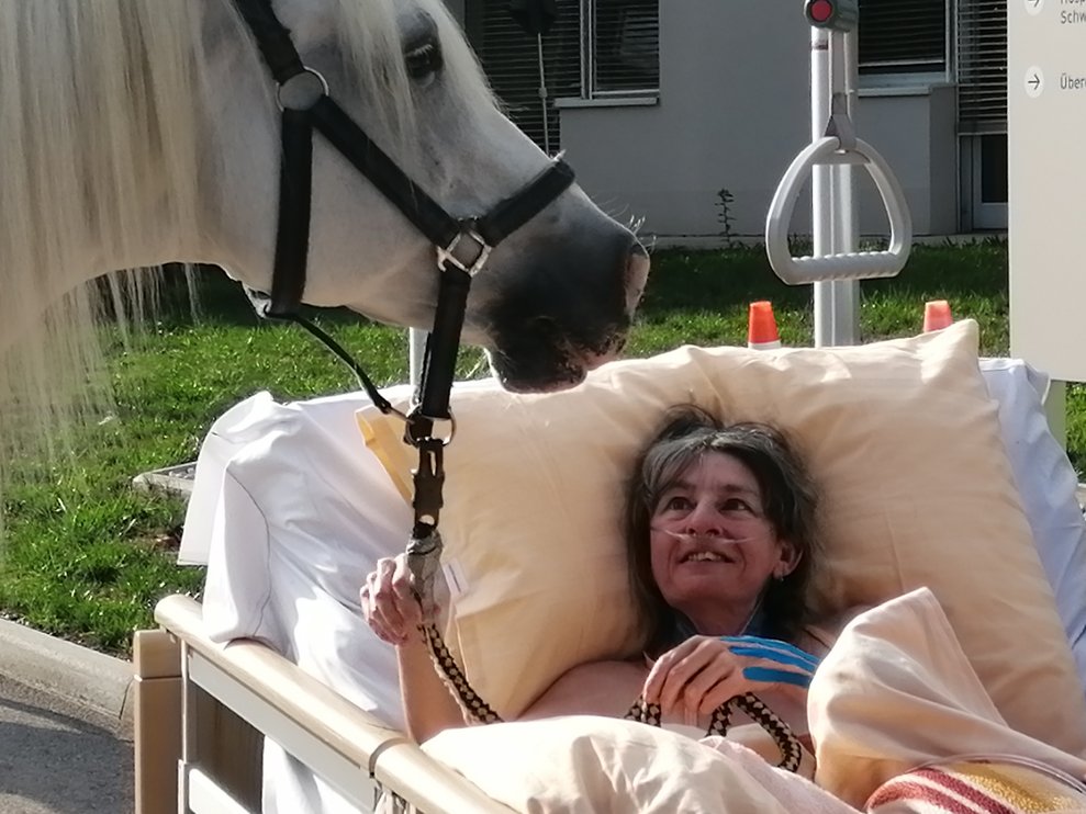 Eine Bewohnerin und ein Pferd.