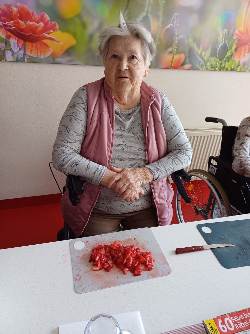 Bewohnerin beim Erdbeeren schneiden