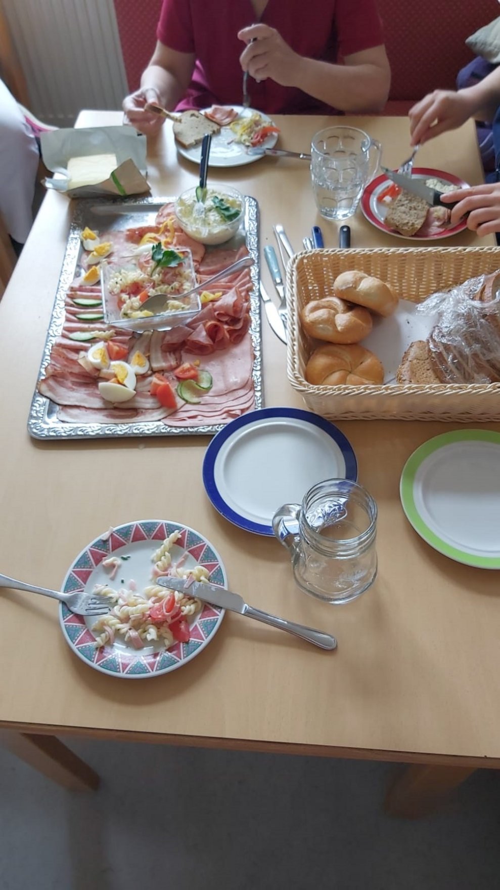 Weckerl und Wurst stehen auf einem Tisch.
