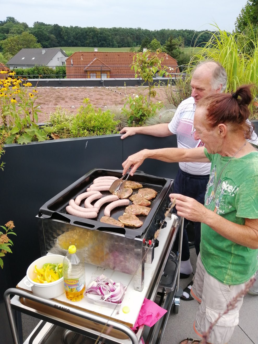 Bewohner stehen beim Grill.