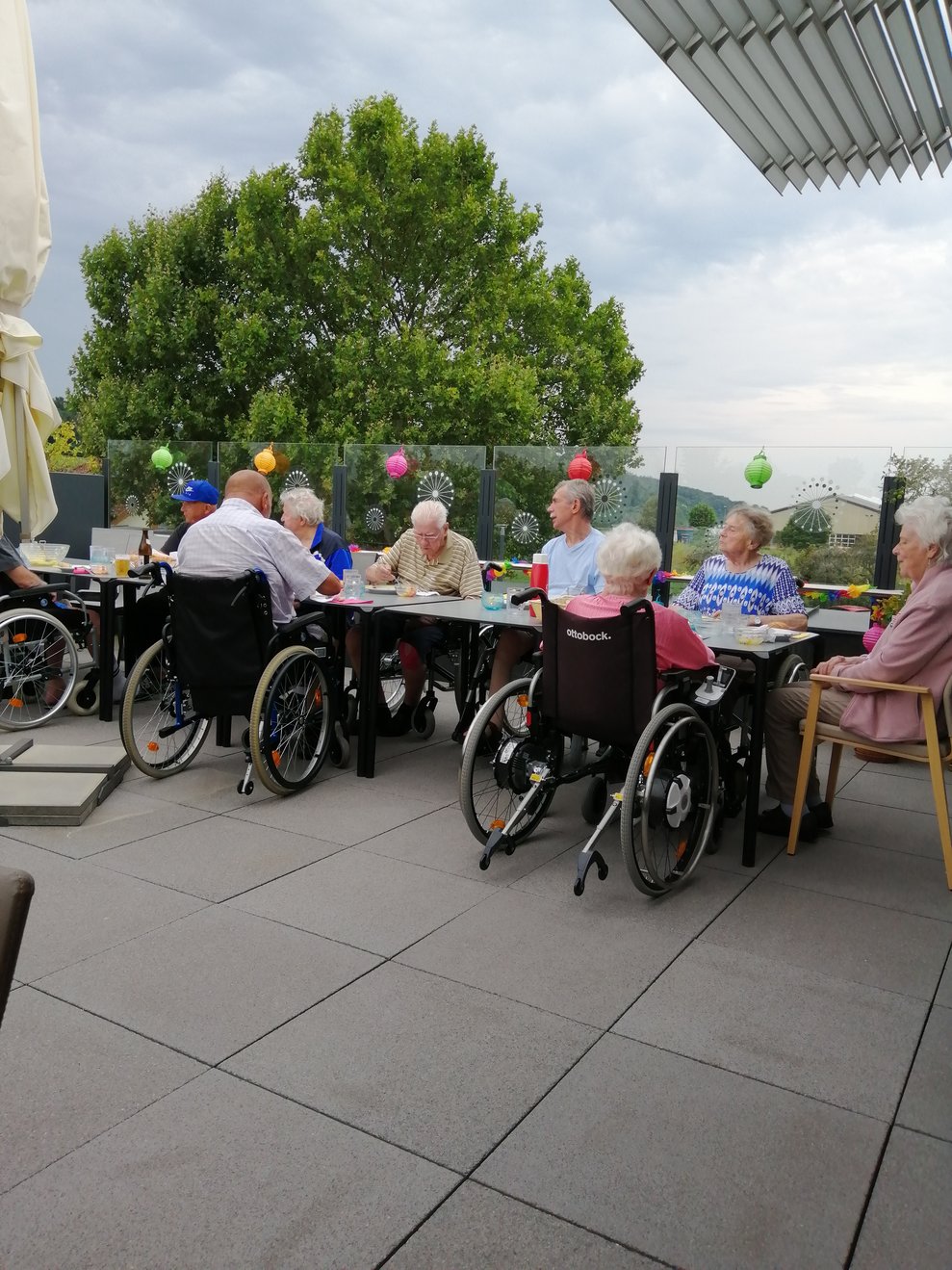 BewohnerInnen sitzen beim Tisch.
