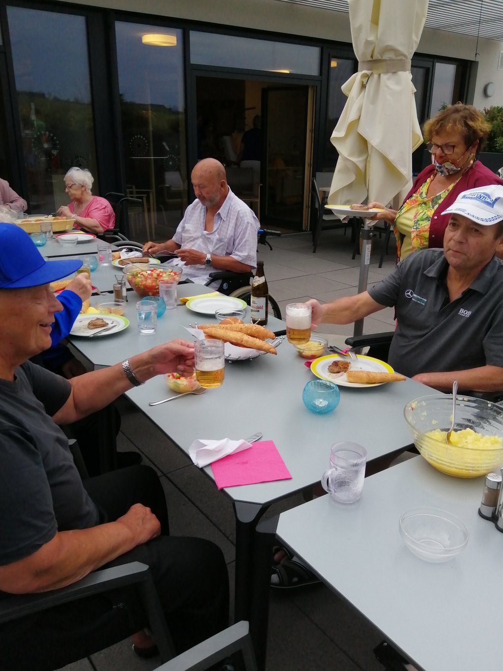 BewohnerInnen sitzen beim Tisch und essen.
