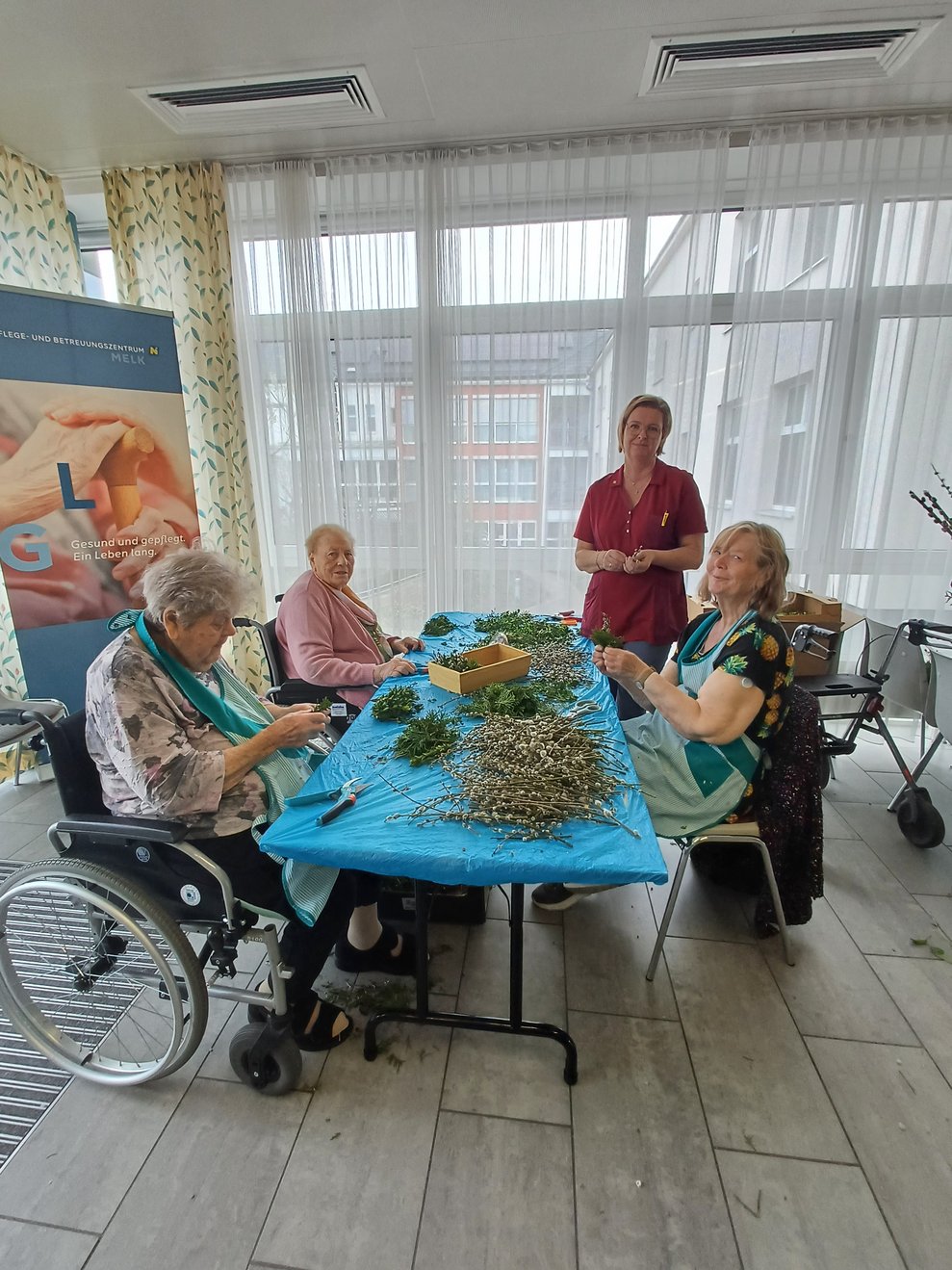 Bewohner und Ehrenamtliche beim Palmbuschen binden.