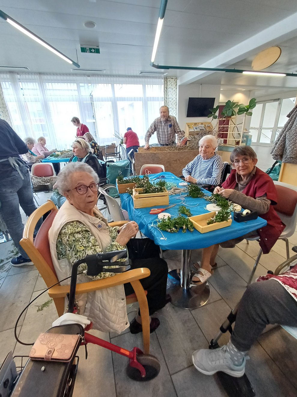 Bewohner und Ehrenamtliche beim Palmbuschen binden.