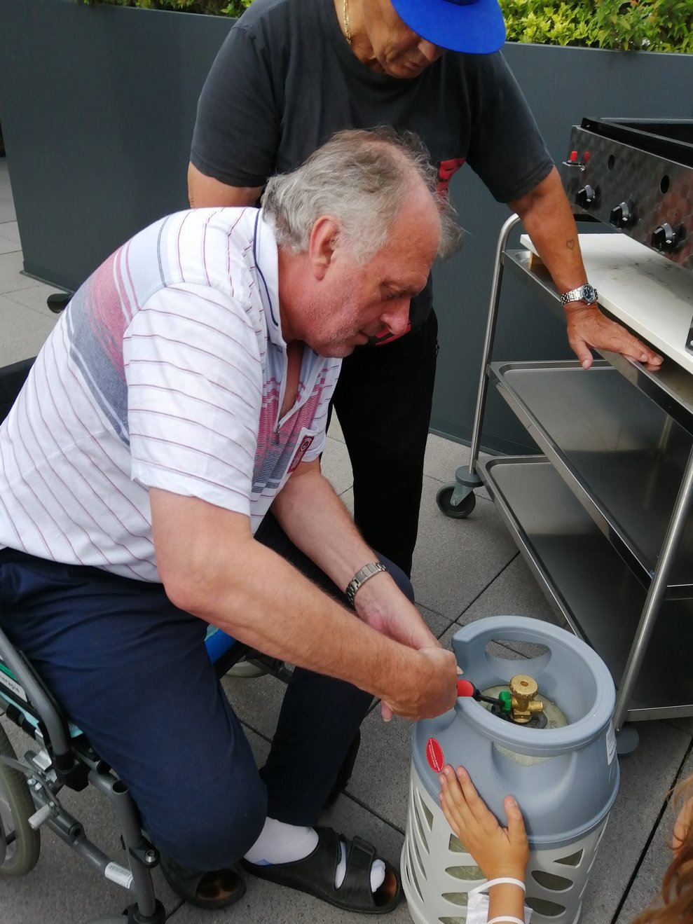 Ein Bewohner steht beim Grill.