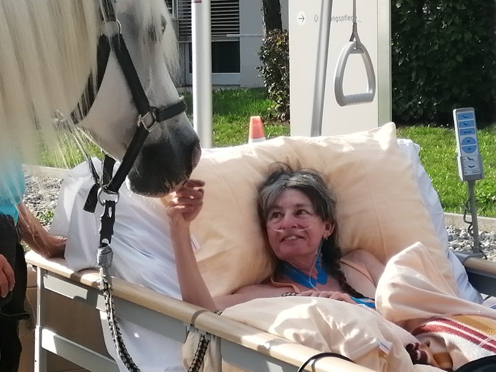 Eine Bewohnerin und ein Pferd.